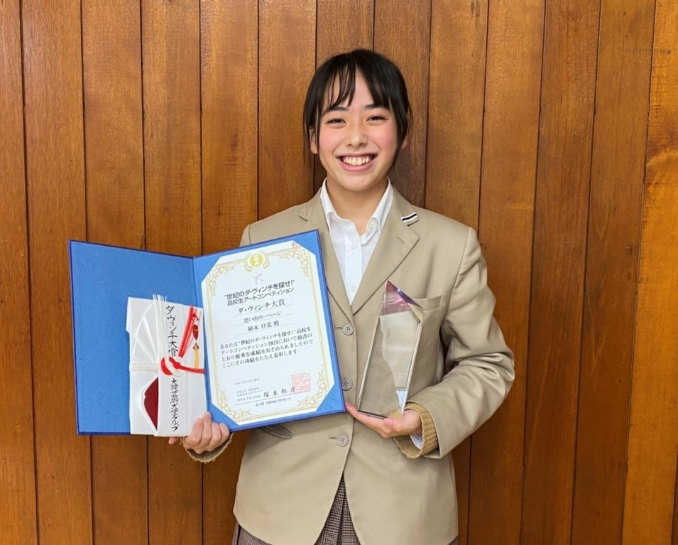 賞状とトロフィーを持つ受賞者